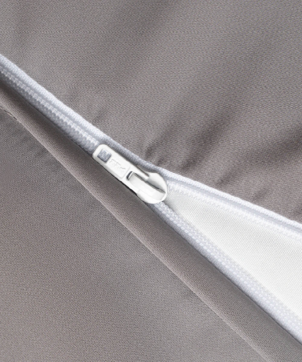 細部拍攝半開 YKK 拉鏈的灰色寢具
