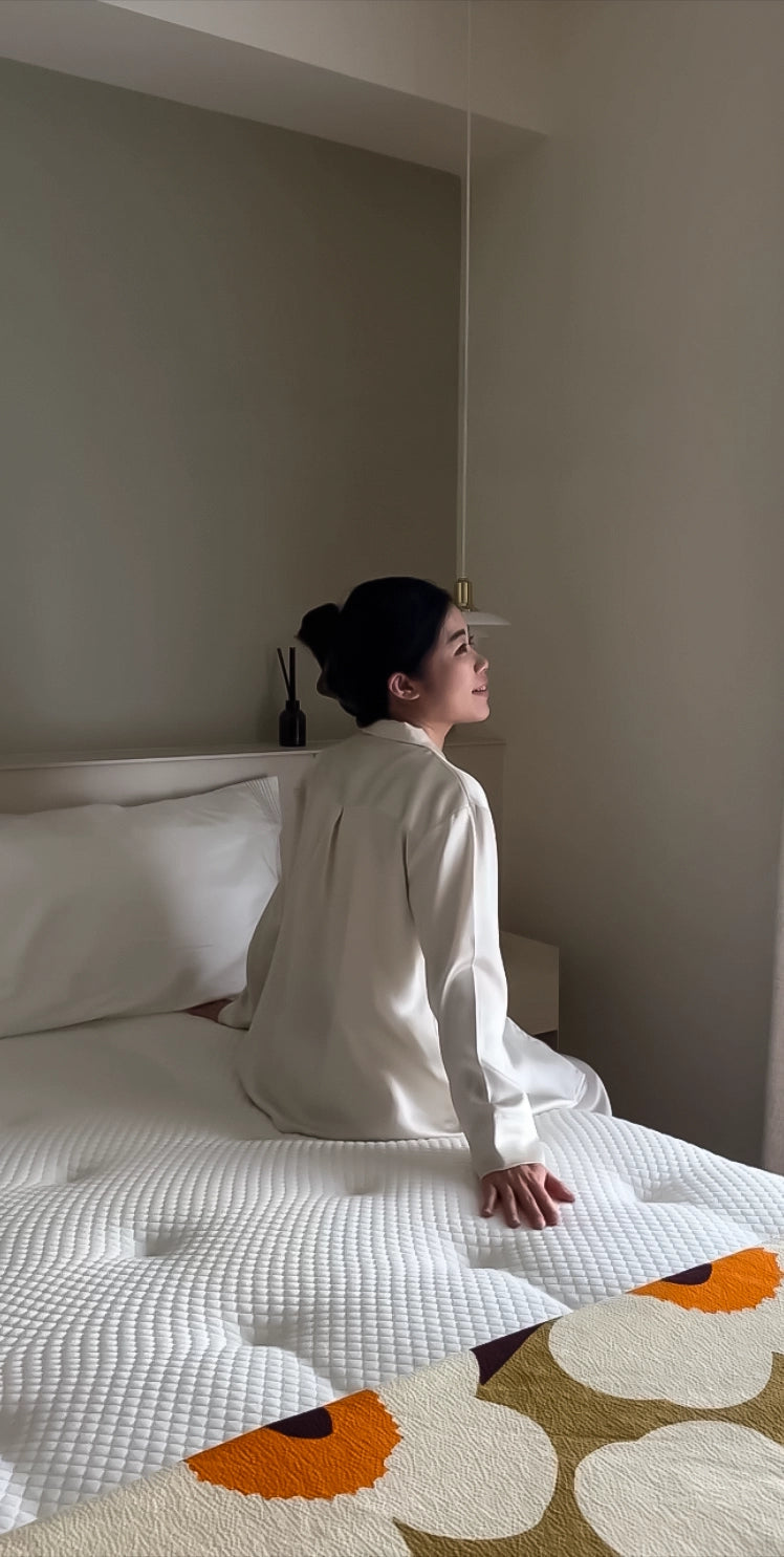 女子於早晨甦醒舒適的坐在床邊望向窗外